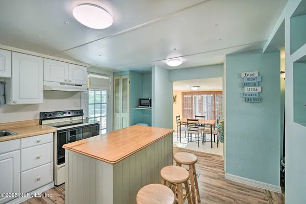a kitchen with a stove a refrigerator a sink dishwasher with a dining table and chairs