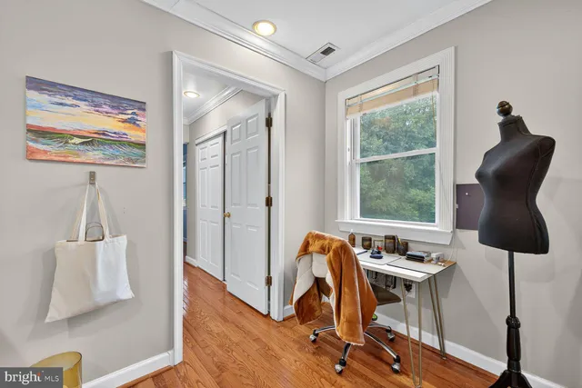 a view of a workspace with furniture and a window