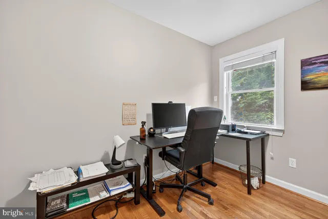 a view of a workspace with furniture and a window