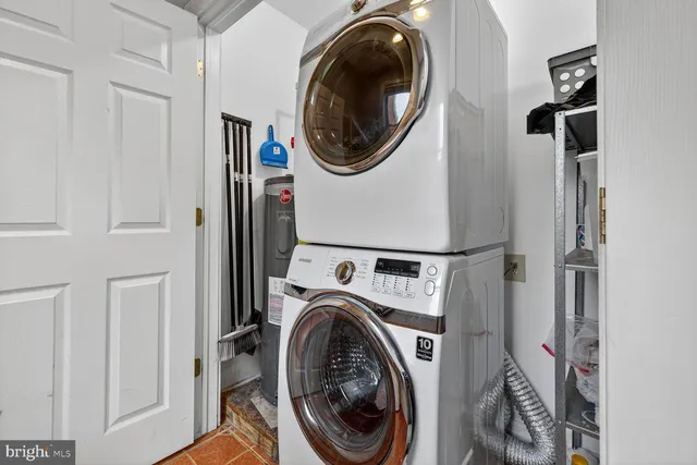 a utility room with dryer washer and a view of storage