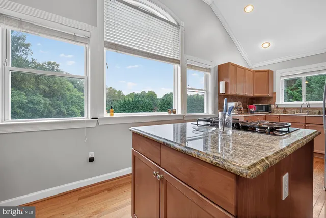 a kitchen with granite countertop a sink a counter top space and cabinets