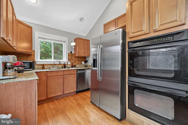 a kitchen with granite countertop stainless steel appliances a stove sink and microwave