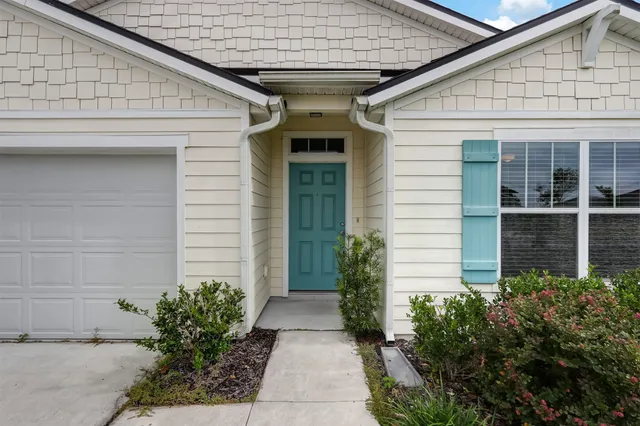a front view of a house with plants