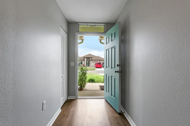 a view of a hallway with wooden floor and entryway