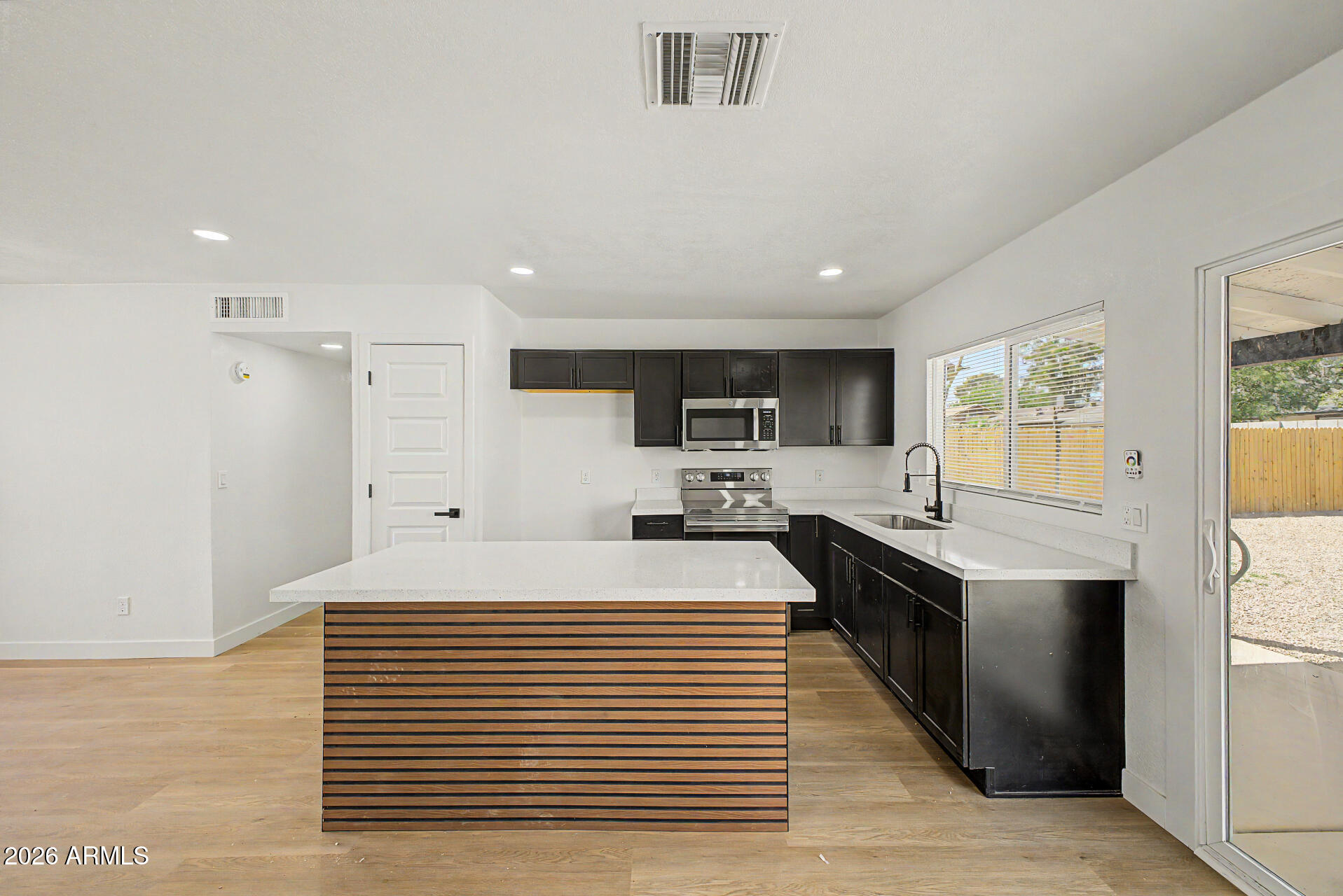 7214 West Flower Street Phoenix, AZ 85033 - Photo 11 of 29 a large white kitchen with stainless steel appliances granite countertop a stove and a sink