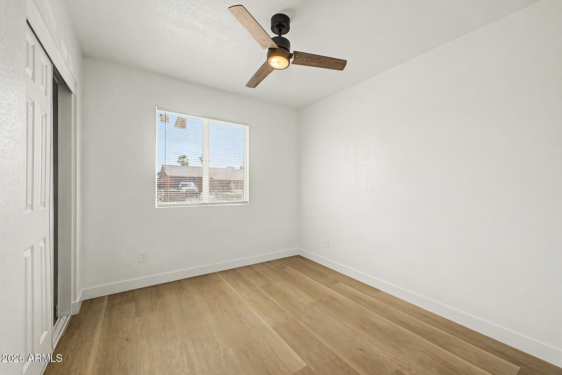7214 West Flower Street Phoenix, AZ 85033 - Photo 17 of 29 an empty room with a window and a ceiling fan