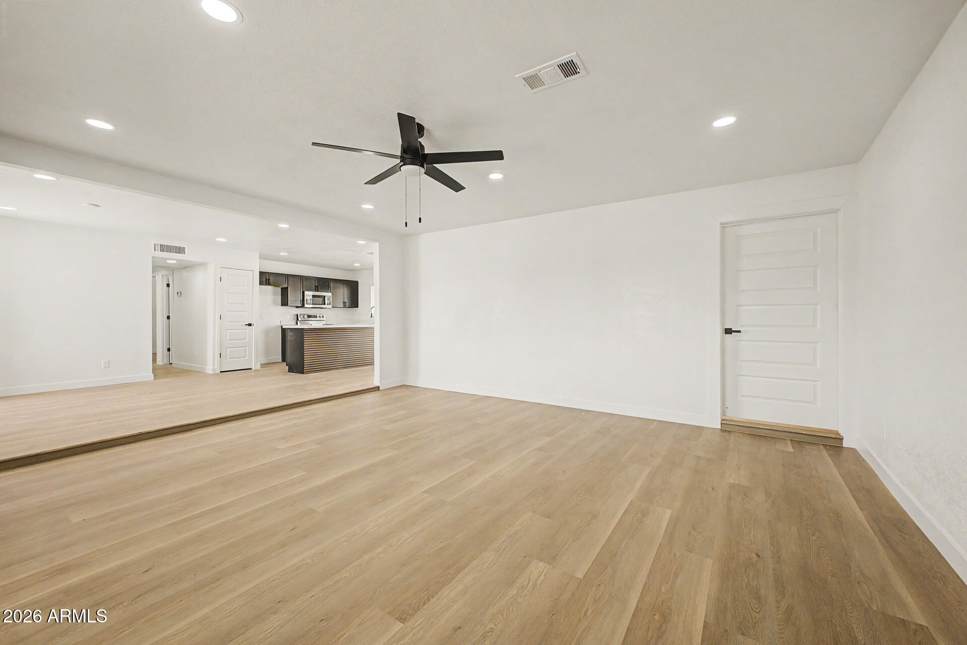 7214 West Flower Street Phoenix, AZ 85033 - Photo 5 of 29 a view of empty room with wooden floor and ceiling fan