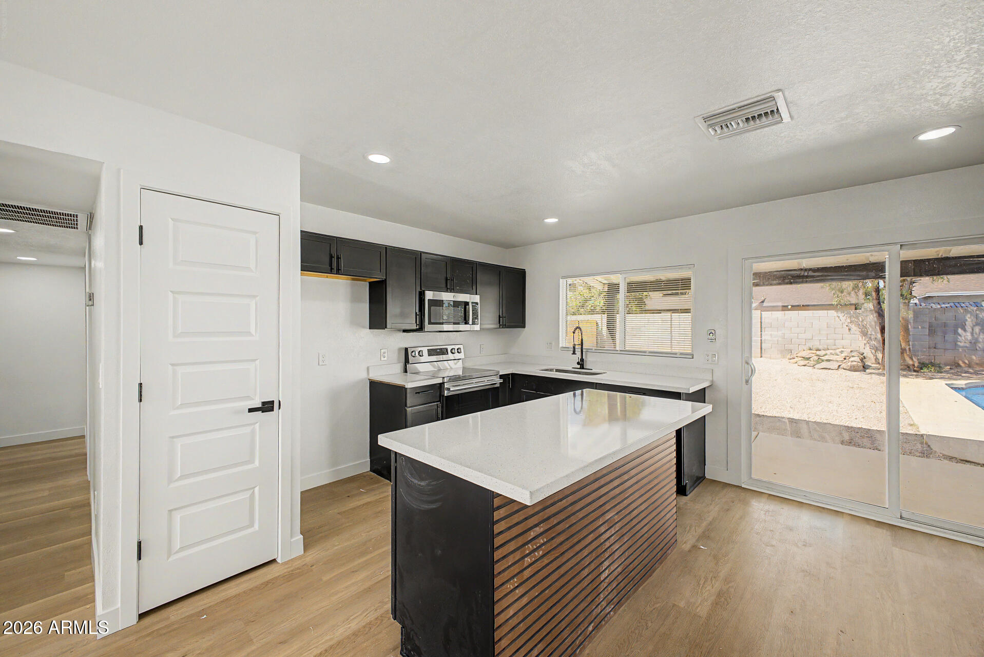 7214 West Flower Street Phoenix, AZ 85033 - Photo 10 of 29 a kitchen with a refrigerator and a stove top oven