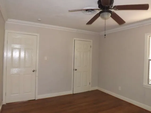 an empty room with closet and a chandelier fan