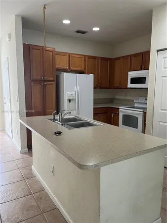 a kitchen with stainless steel appliances a refrigerator sink and microwave
