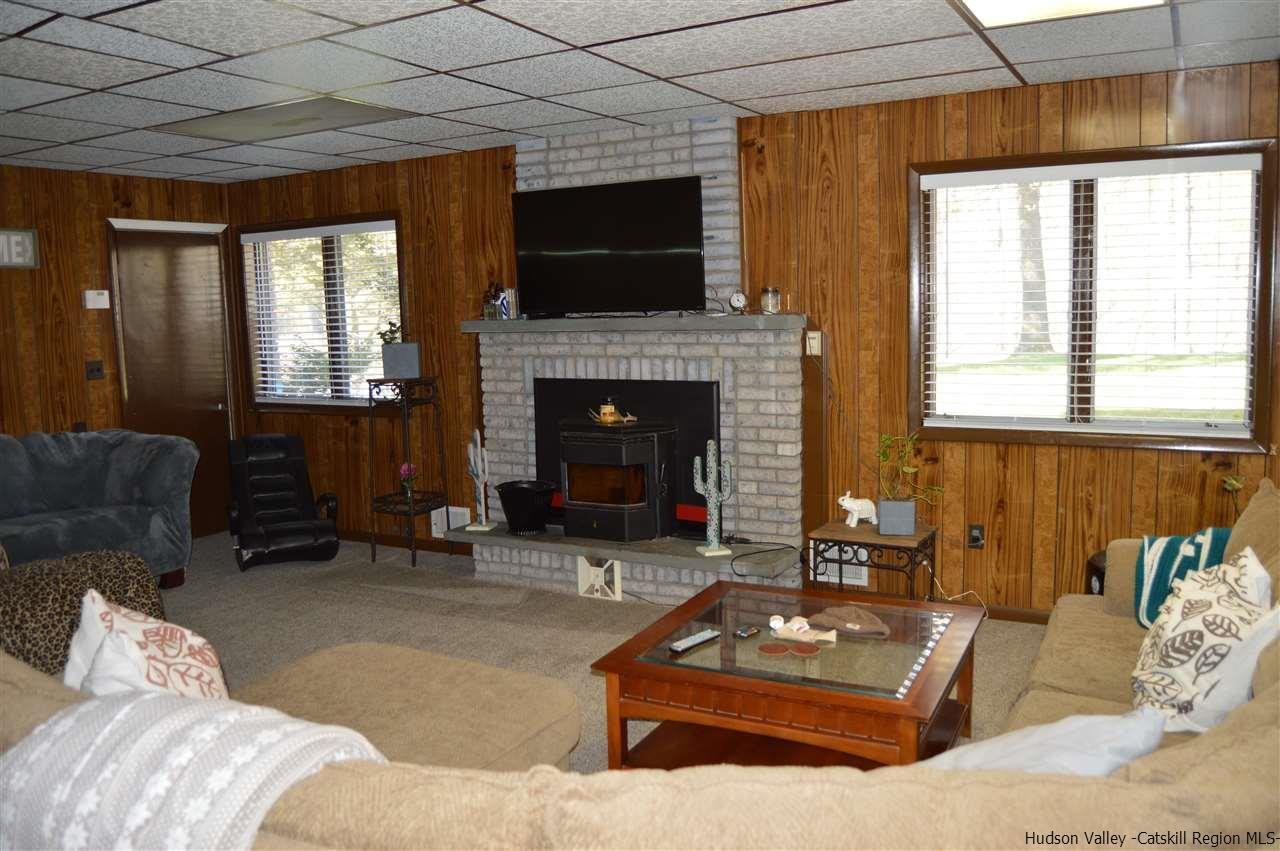 8 Skytop Drive Kingston, NY 12401 - Photo 18 of 23 a living room with furniture a flat screen tv and a fireplace
