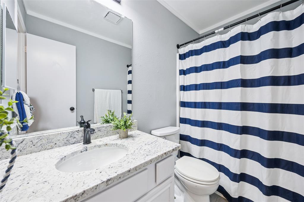 621 Renaissance Place Cedar Hill, TX 75104 - Photo 20 of 28 a bathroom with a granite countertop toilet a sink and a mirror