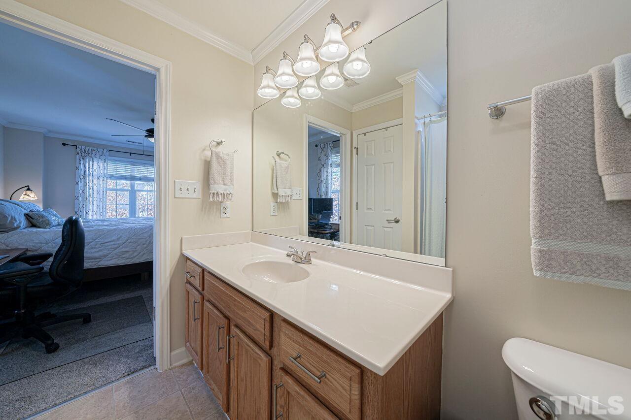 4500 Centrebrook Circle Raleigh, NC 27616 - Photo 29 of 39 a bathroom with a sink a toilet a mirror a vanity and window
