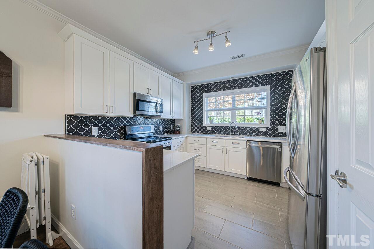 4500 Centrebrook Circle Raleigh, NC 27616 - Photo 8 of 39 a kitchen with a refrigerator and a stove top oven