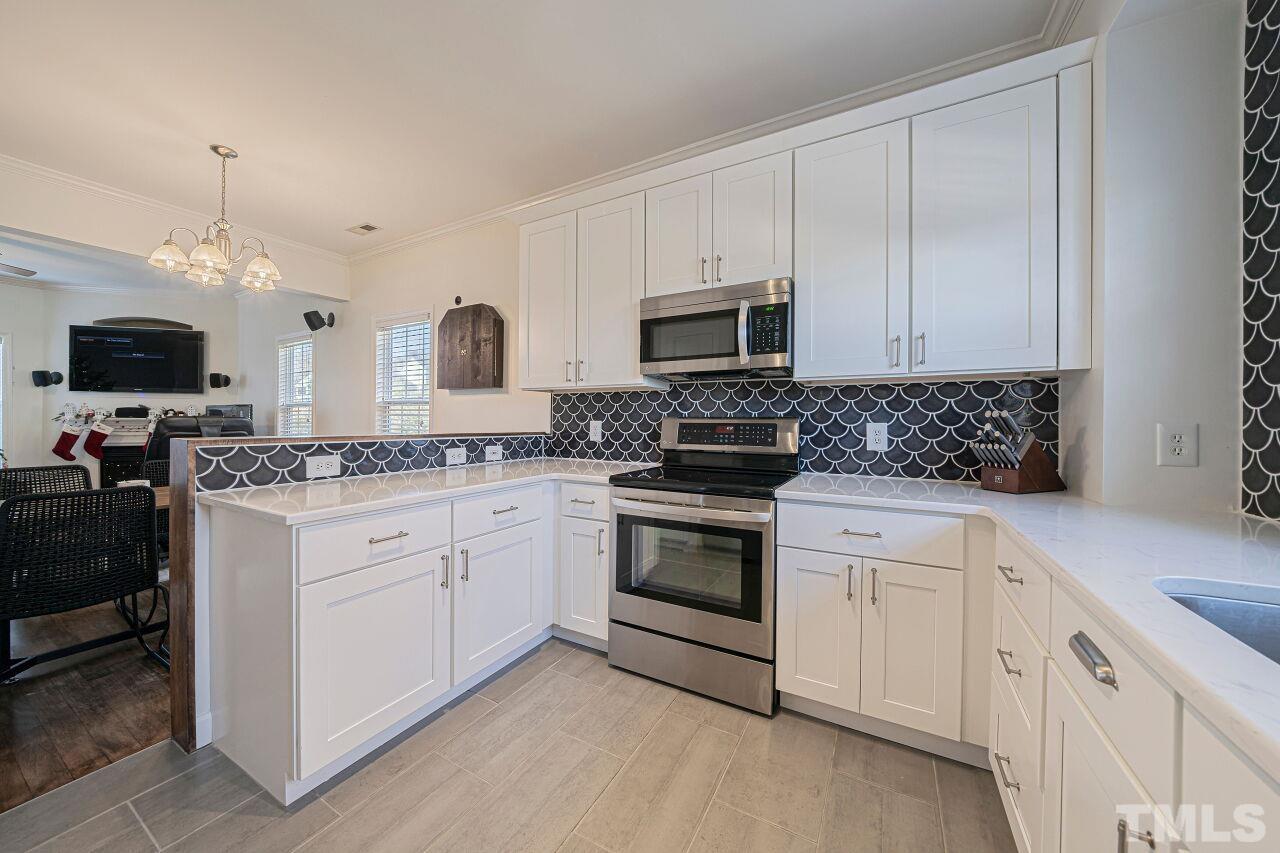 4500 Centrebrook Circle Raleigh, NC 27616 - Photo 9 of 39 a kitchen with white cabinets and appliances
