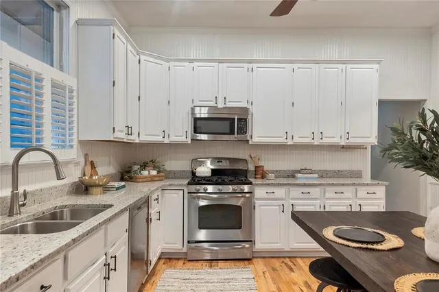 a kitchen with granite countertop a stove a sink and a microwave
