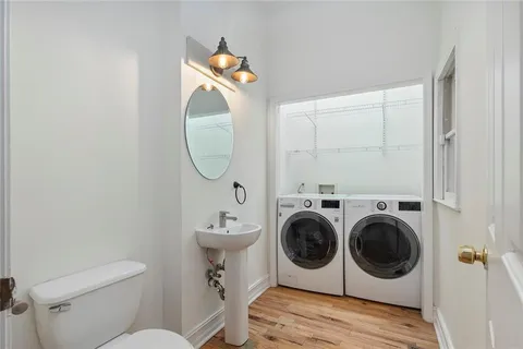 a utility room with dryer washer and a wooden floor