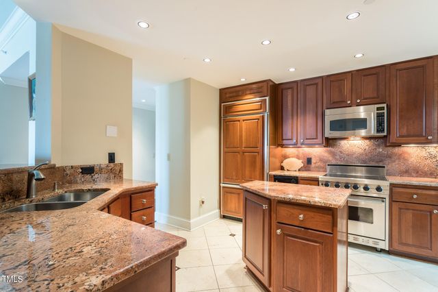 a kitchen with stainless steel appliances granite countertop a stove a sink and a refrigerator