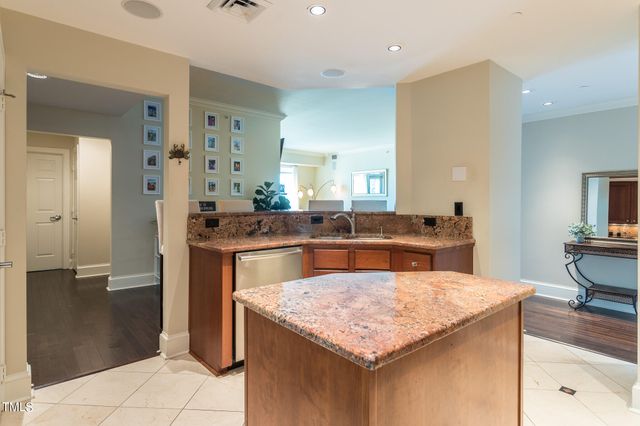 a kitchen with kitchen island granite countertop wooden cabinets and a counter space