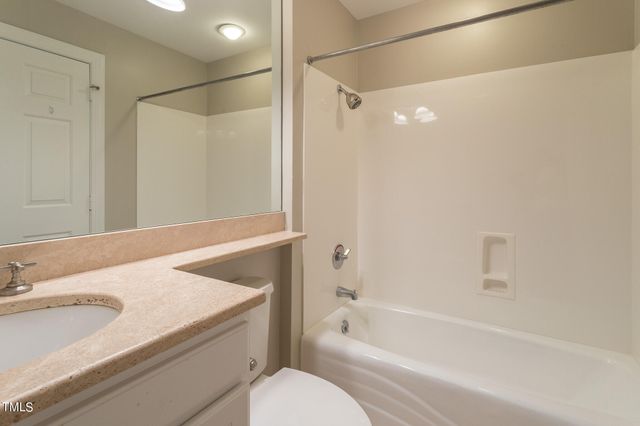 a bathroom with a granite countertop sink a toilet and shower