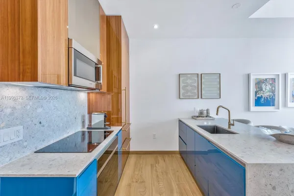 a kitchen with granite countertop a sink a stove and cabinets