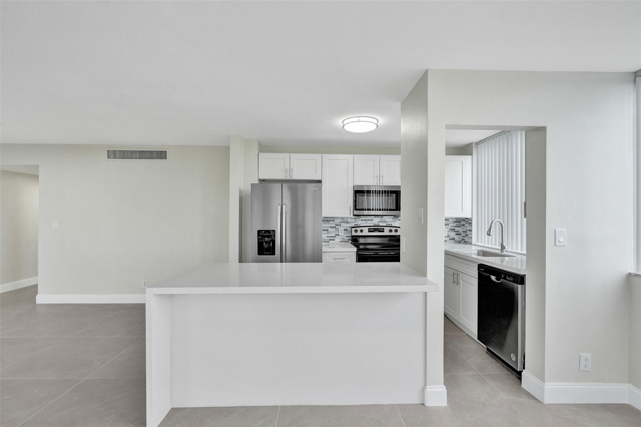 4222 Inverrary Boulevard, Unit 4810 Lauderhill, FL 33319 - Photo 11 of 63 a kitchen with stainless steel appliances a refrigerator sink and stove