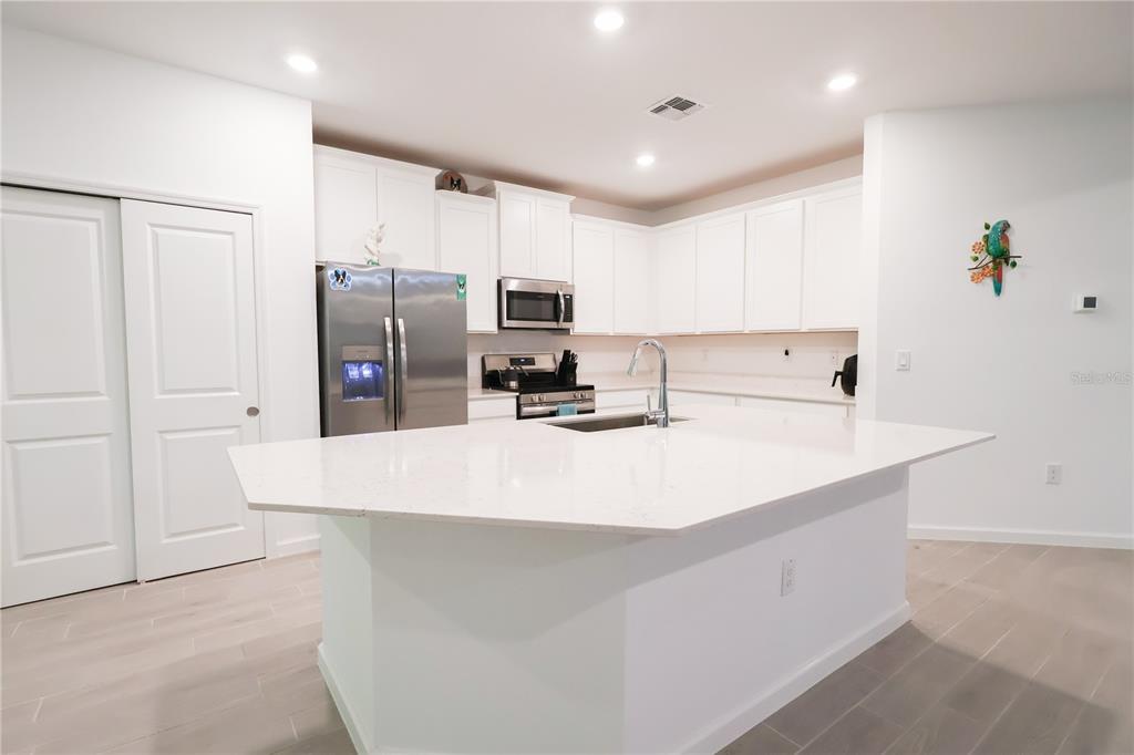 19511 Southwest 77th Loop Dunnellon, FL 34432 - Photo 7 of 27 a kitchen with kitchen island white cabinets and stainless steel appliances