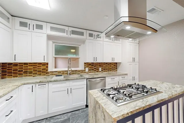 a kitchen with a stove and a wooden floor