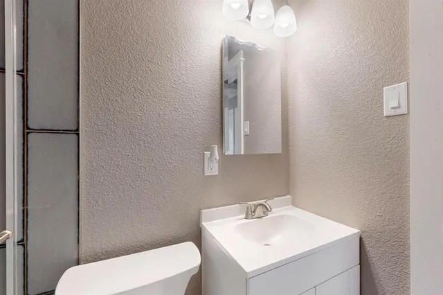 a white toilet sitting next to a bathroom sink