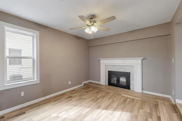 a room with a fireplace and ceiling fan