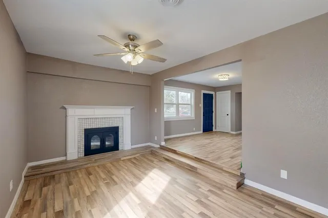 a view of an empty room with window and fire place