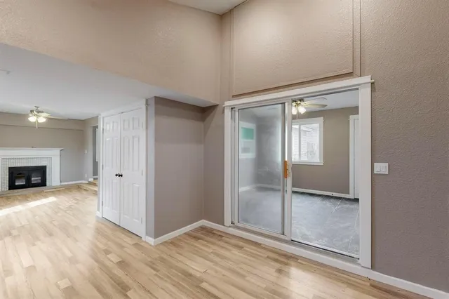 an empty room with wooden floor and fireplace