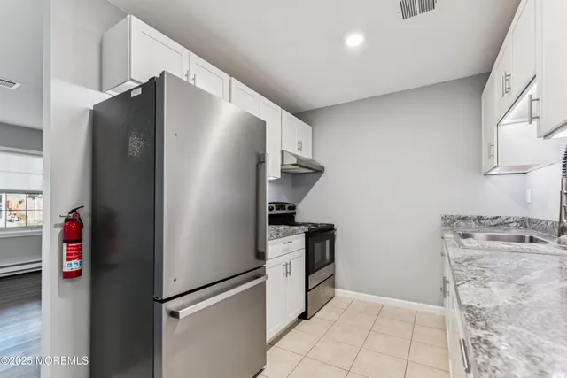 a kitchen with stainless steel appliances granite countertop a refrigerator and a stove
