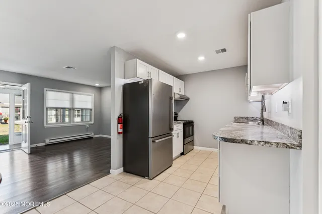 a kitchen with stainless steel appliances granite countertop a refrigerator and a sink