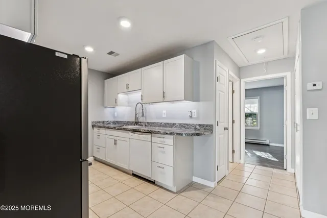 a kitchen with granite countertop cabinets and refrigerator