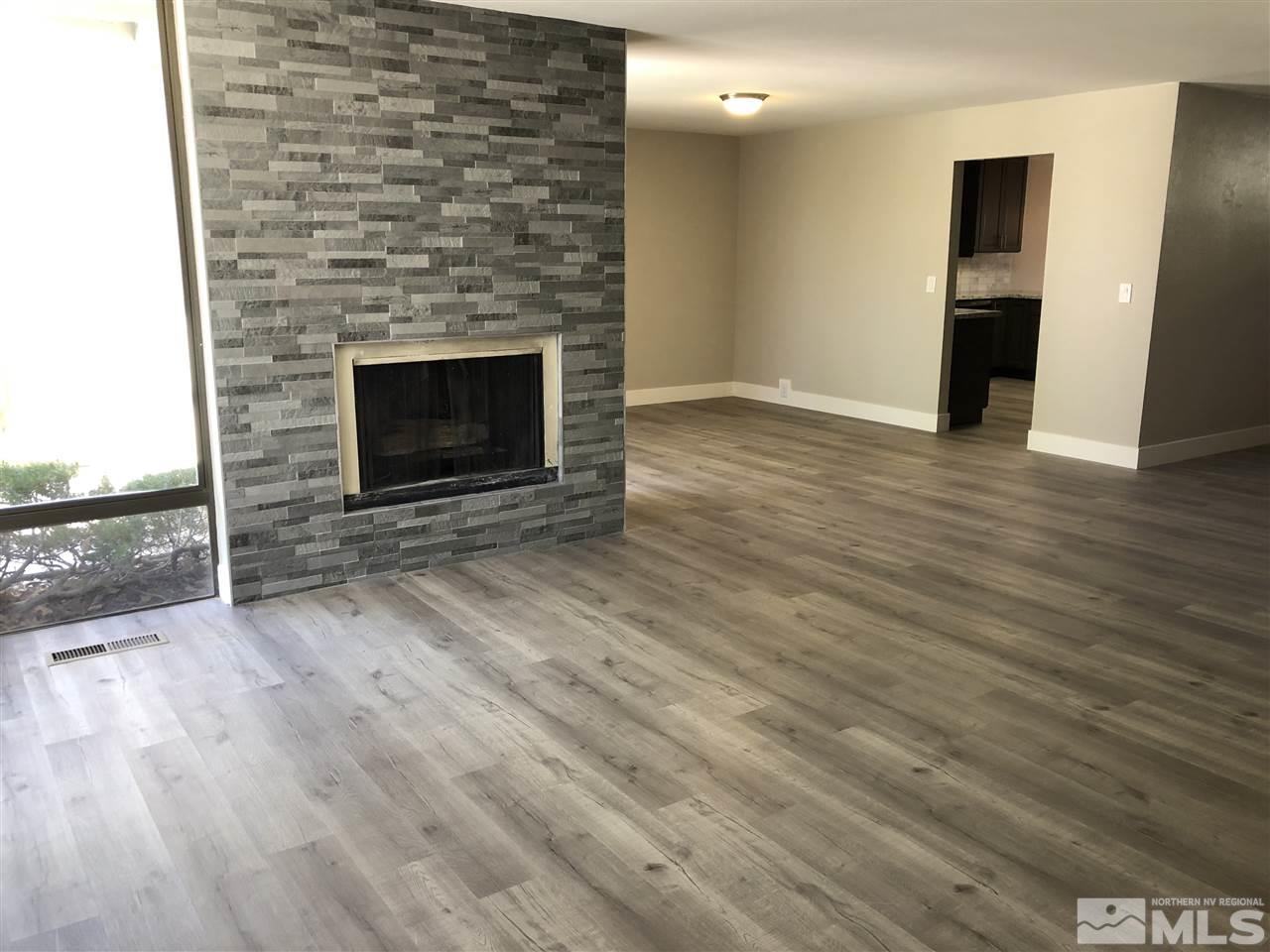 4980 Plumas Street Reno, NV 89509 - Photo 6 of 20 an empty room with wooden floor and fireplace