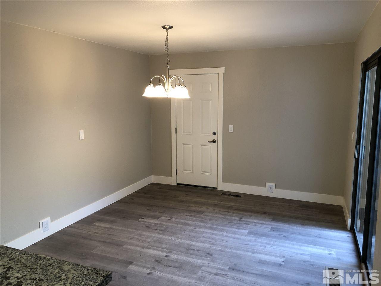 4980 Plumas Street Reno, NV 89509 - Photo 8 of 20 an empty room with wooden floor and chandelier