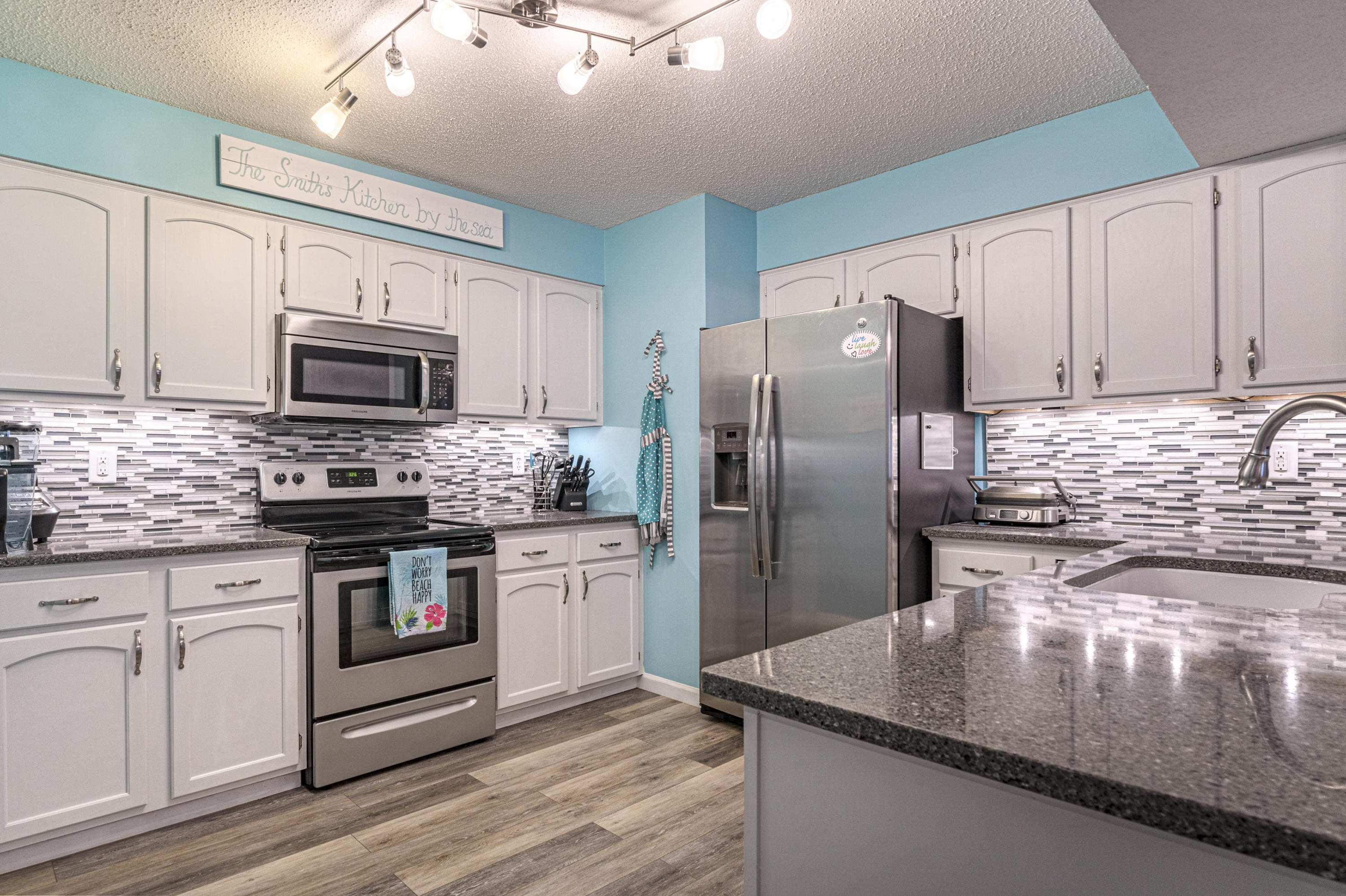 520 Springwood Way Niceville, FL 32578 - Photo 3 of 5 a kitchen with stainless steel appliances granite countertop a stove a refrigerator a sink a microwave oven with a dining table and chairs