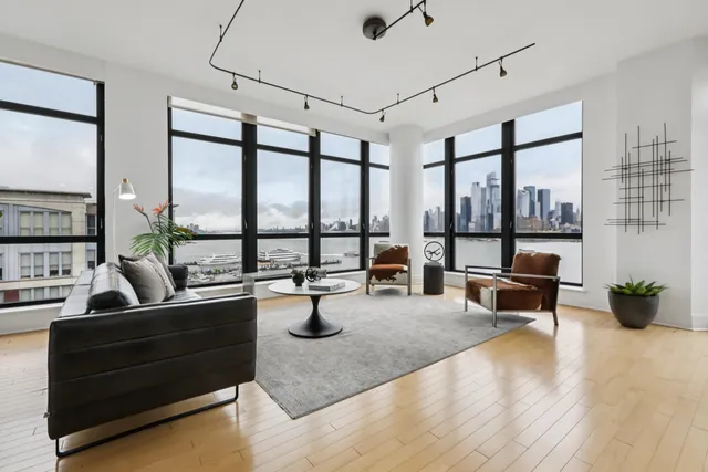 a living room with furniture and floor to ceiling windows