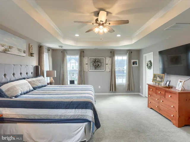 a bedroom with a large bed and a flat tv screen on dresser