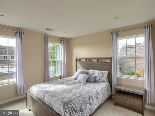 a large bed sitting in a bedroom next to a window