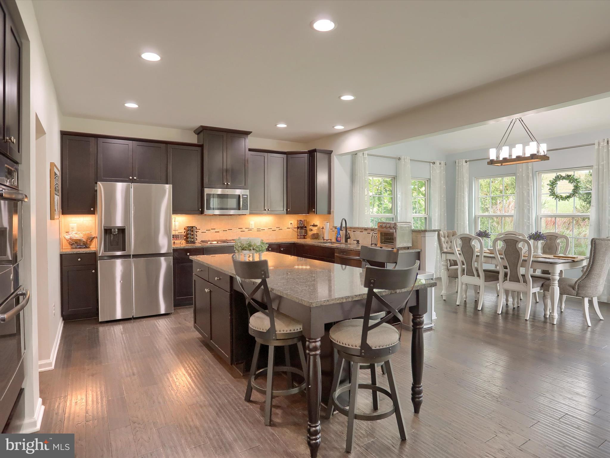 3930 Seattle Slew Drive Harrisburg, PA 17112 - Photo 9 of 48 a kitchen with stainless steel appliances a dining table chairs refrigerator and sink