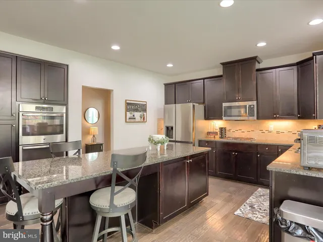 a kitchen with granite countertop sink table and chairs