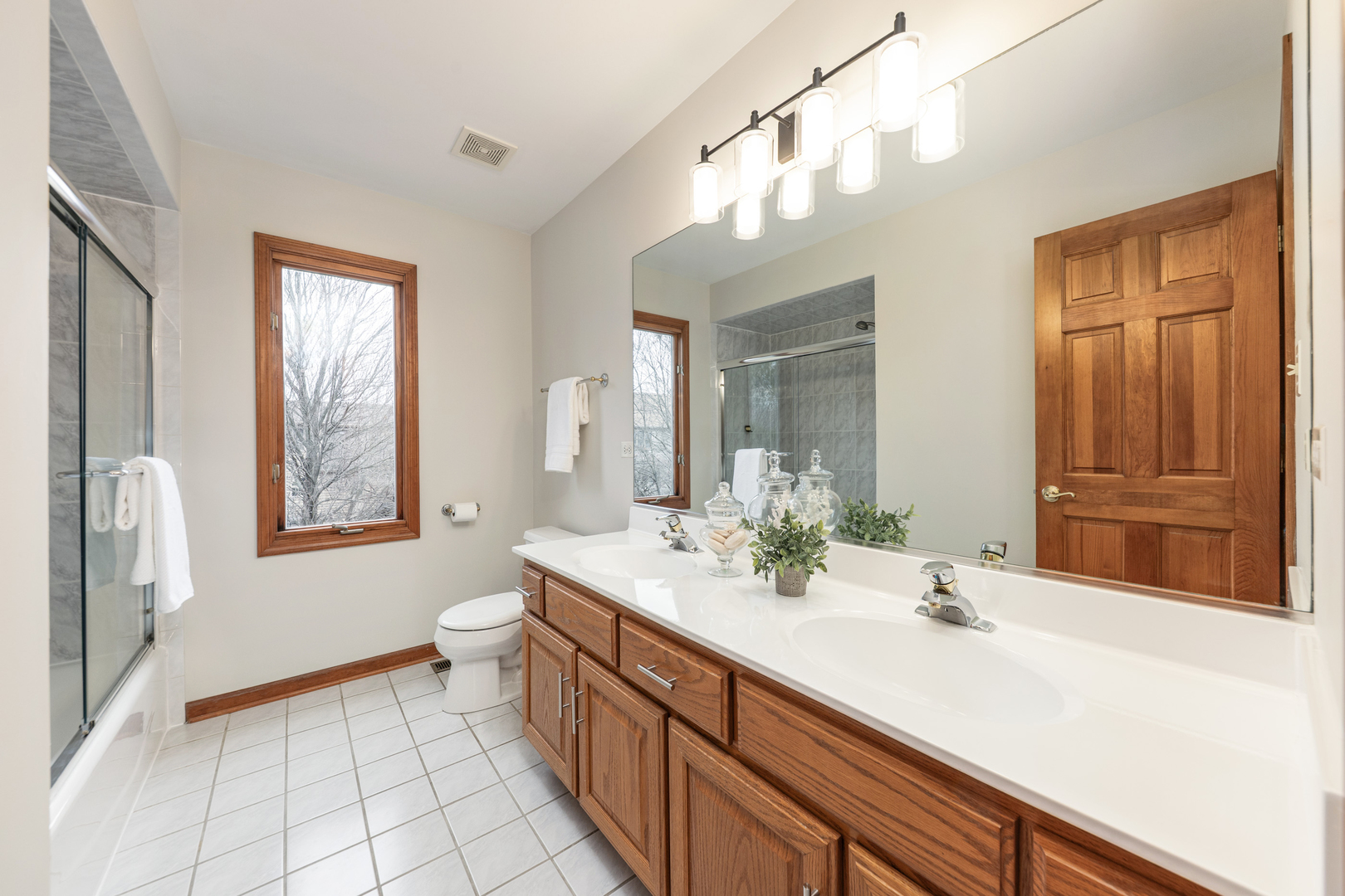 2703 Wait Road Naperville, IL 60564 - Photo 21 of 35 a bathroom with a double vanity sink a mirror and a bathtub