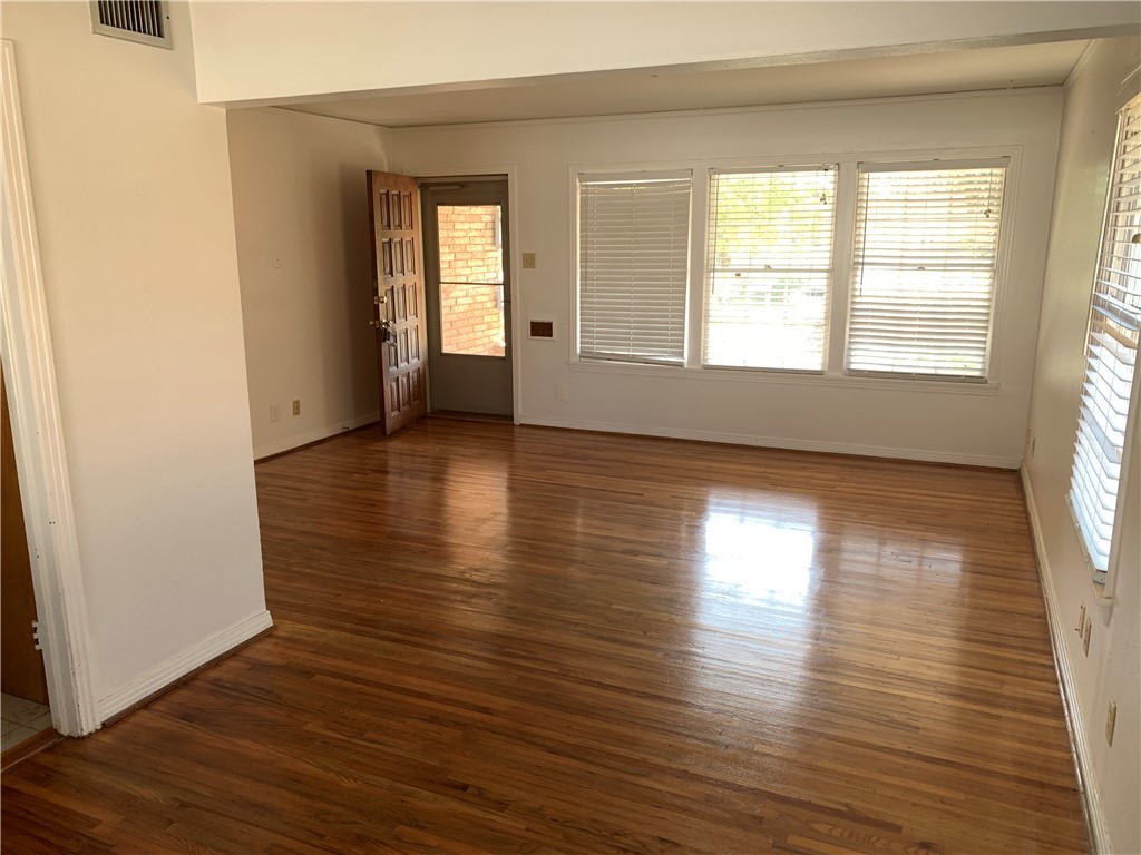 606 Hopper Drive Corpus Christi, TX 78411 - Photo 2 of 8 an empty room with wooden floor and windows