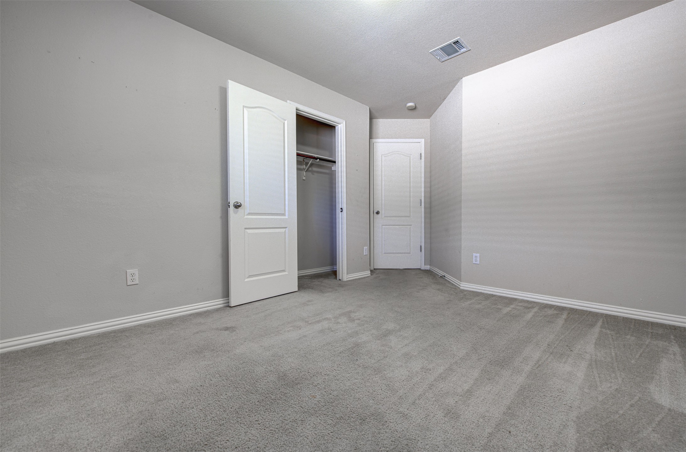 2090 Intrepid Drive Buda, TX 78610 - Photo 17 of 24 Unfurnished bedroom featuring light carpet and a closet
