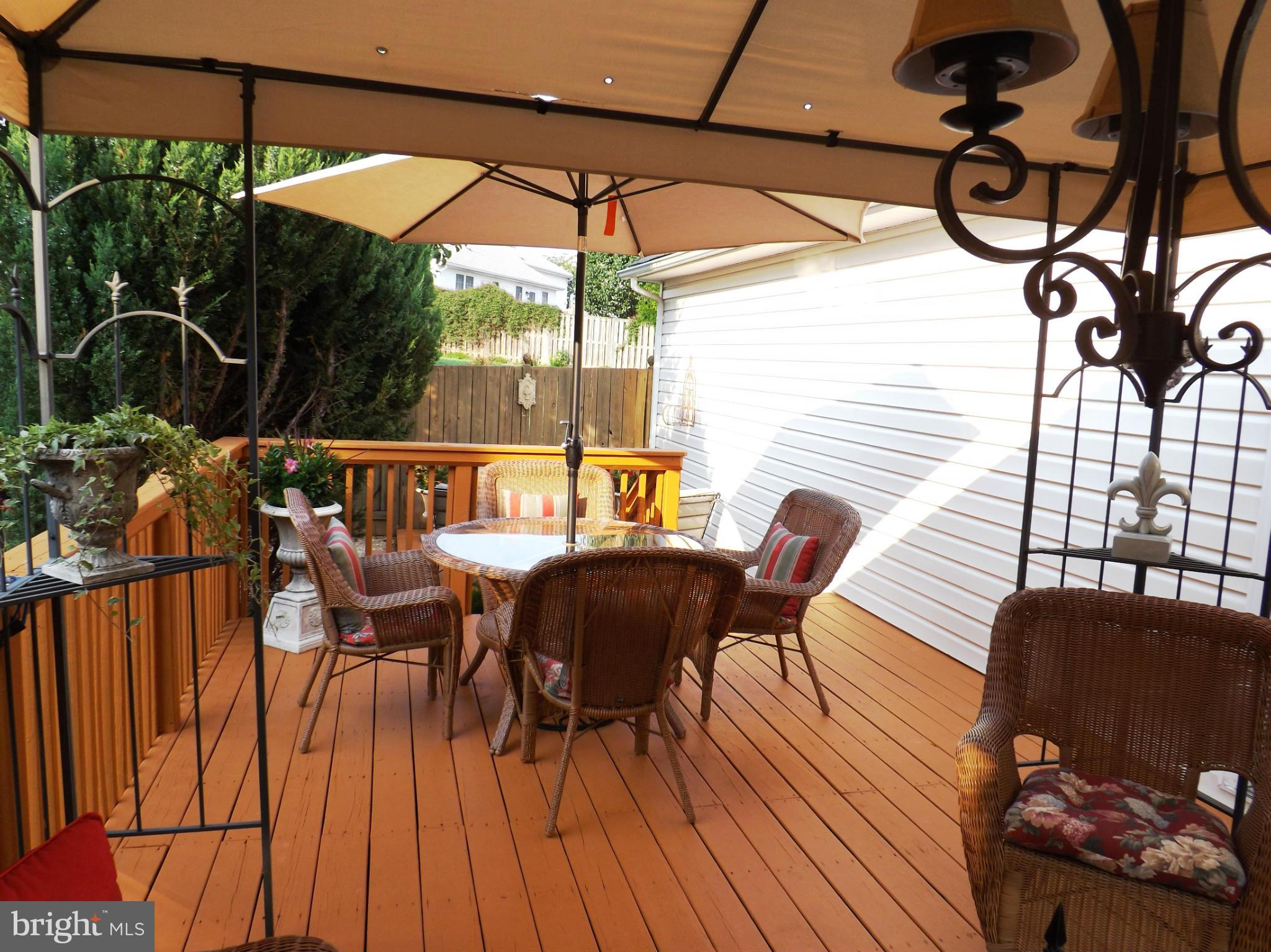 36 Roger Court Ranson, WV 25438 - Photo 20 of 29 a view of a patio with table and chairs under an umbrella with wooden floor