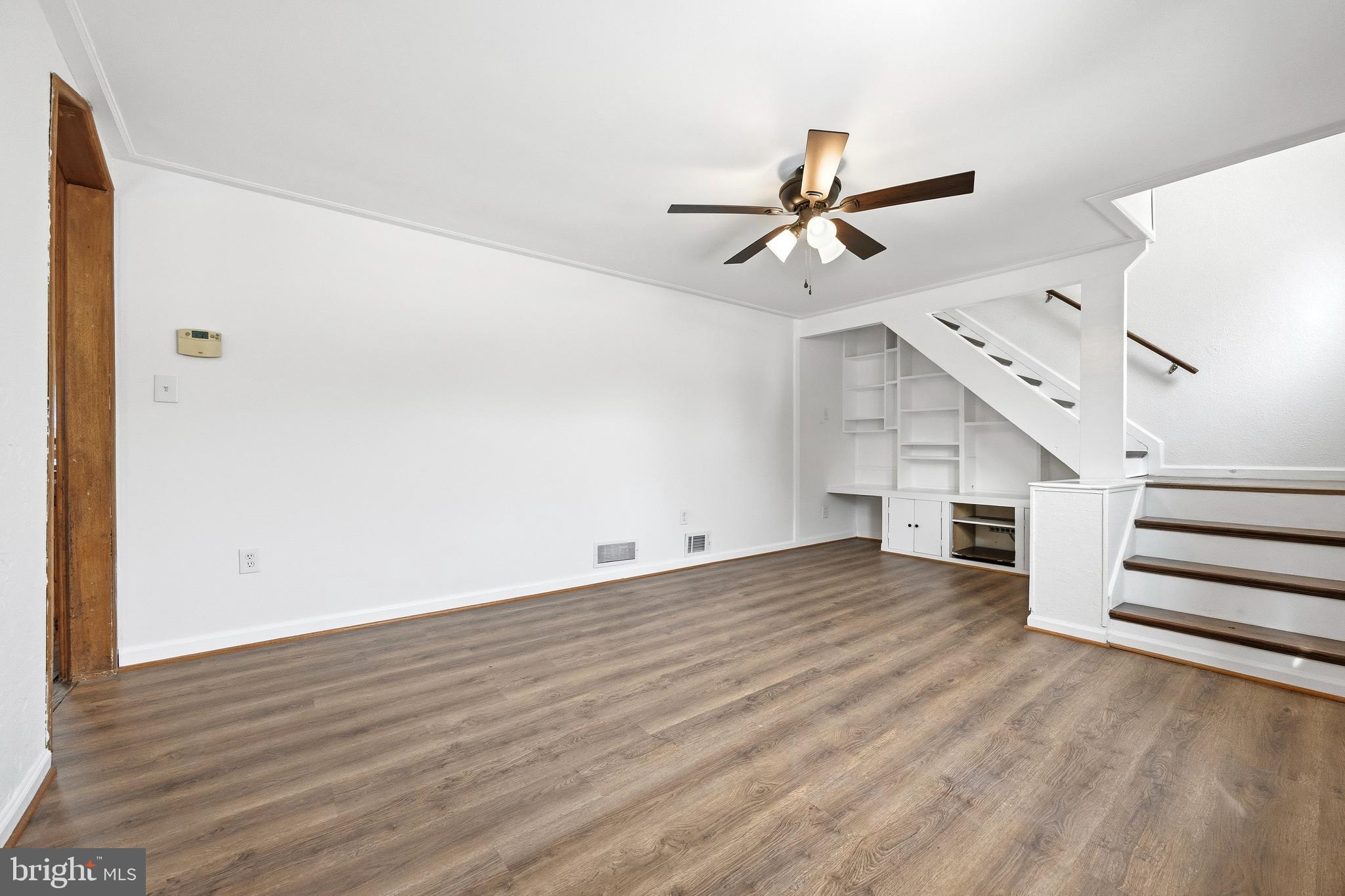 652 Chapelview Drive Odenton, MD 21113 - Photo 9 of 50 an empty room with wooden floor ceiling fan and windows