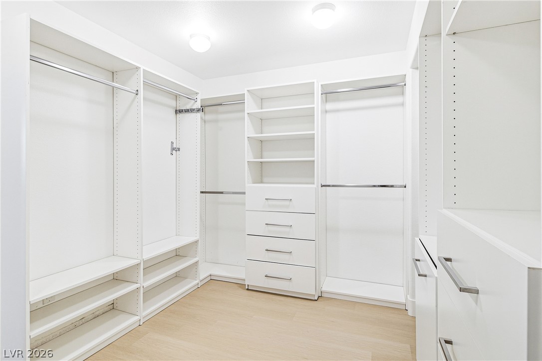 2182 Trivero Street Henderson, NV 89044 - Photo 33 of 50 A spacious custom closet offers extensive built-in shelving, hanging rods, and drawers.