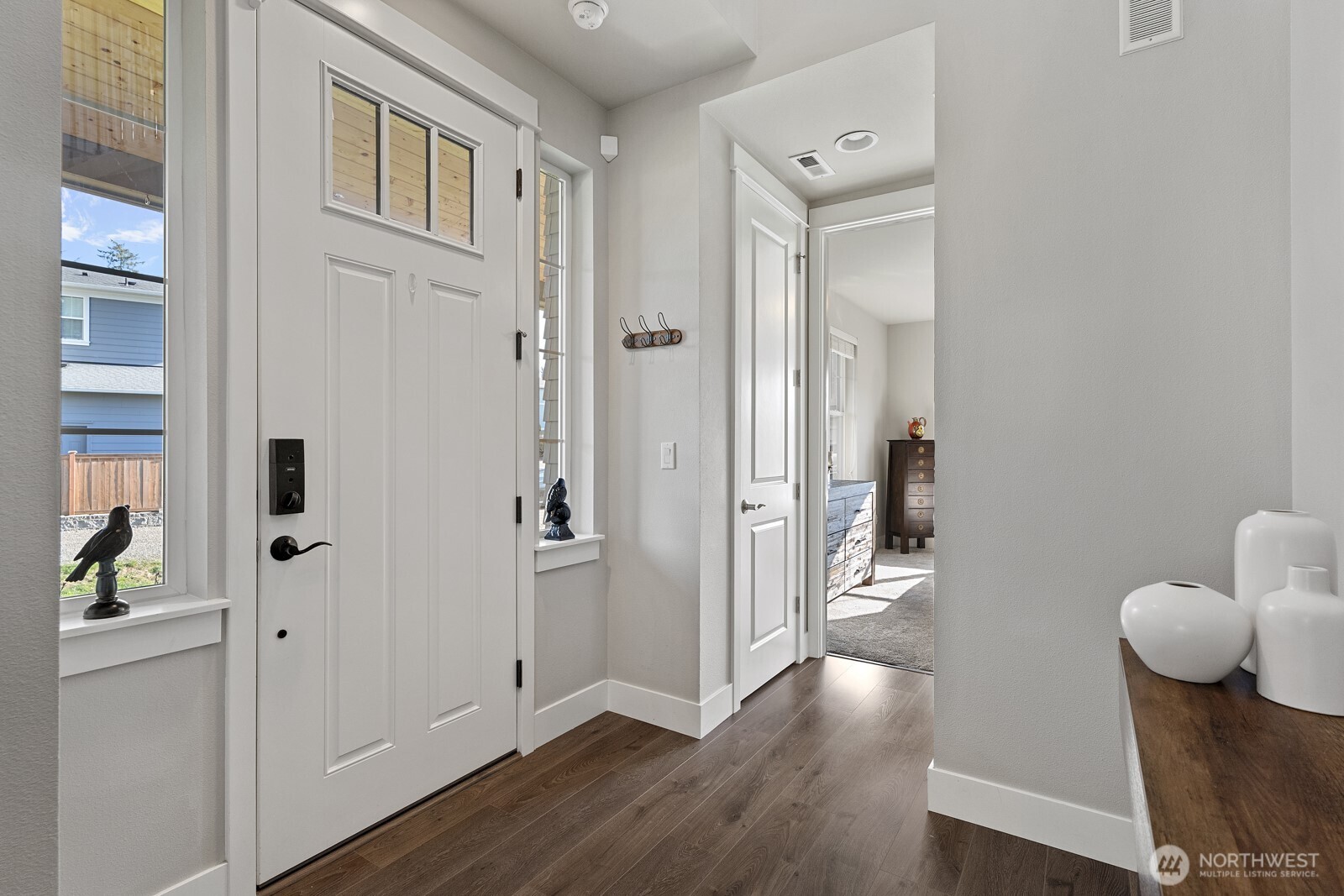 22752 Southeast 265th Place Maple Valley, WA 98038 - Photo 4 of 39 a view of a hallway with wooden floor and glass door